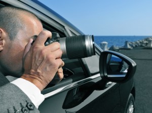 detective or paparazzi taking photos from inside a car